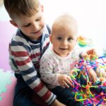 Cute little children playing while sitting on carpet